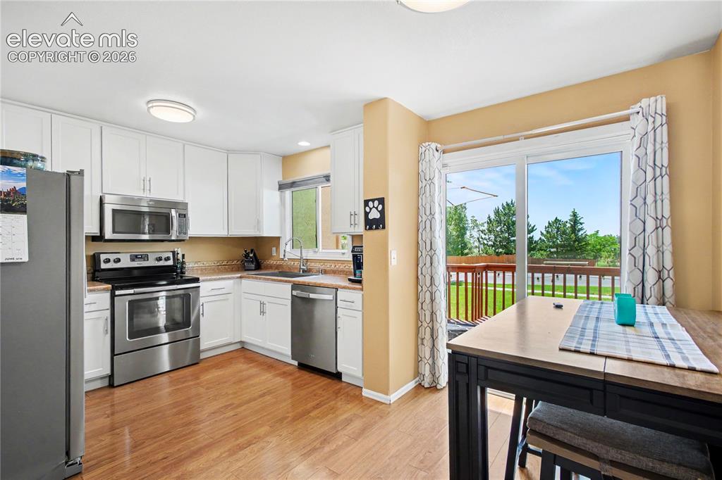 Image 10 of 25: Bright kitchen and dining area leading to oversized deck
