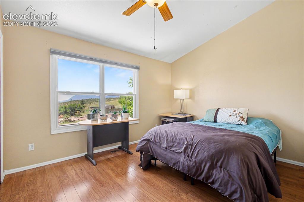 Image 15 of 25: Upper level guest bedroom with large window and view of mountains