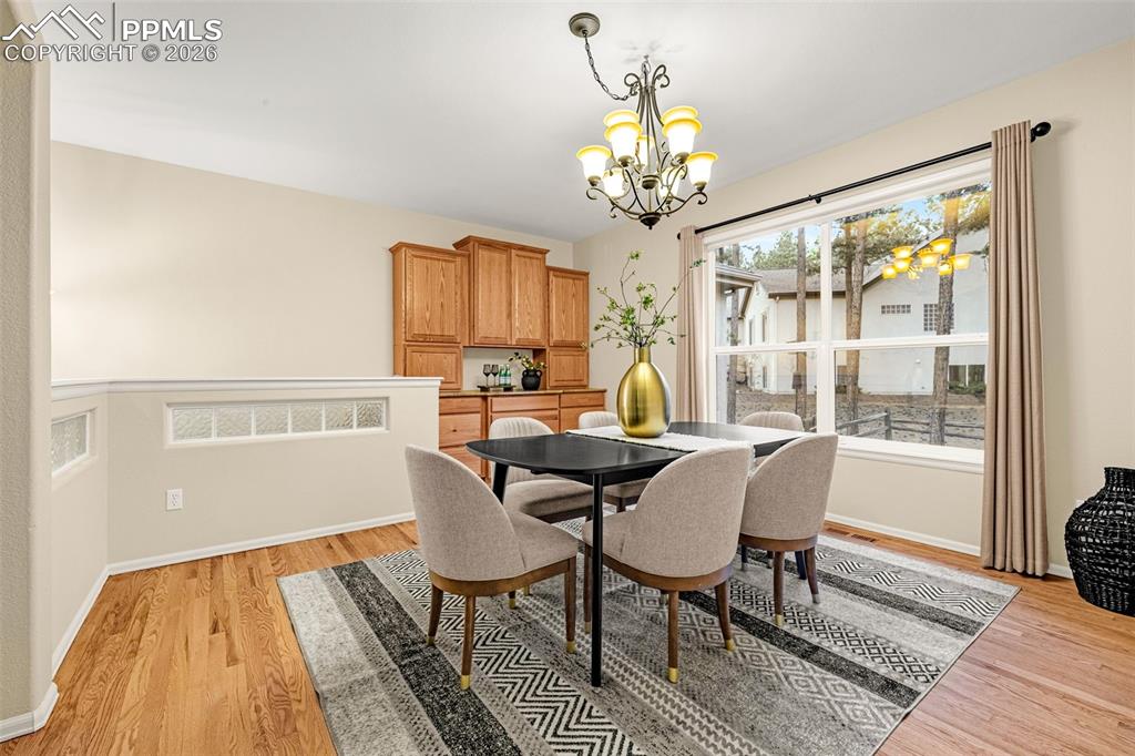 Image 10 of 40: Dining area featuring hardwood floors, a large window providing natural lig