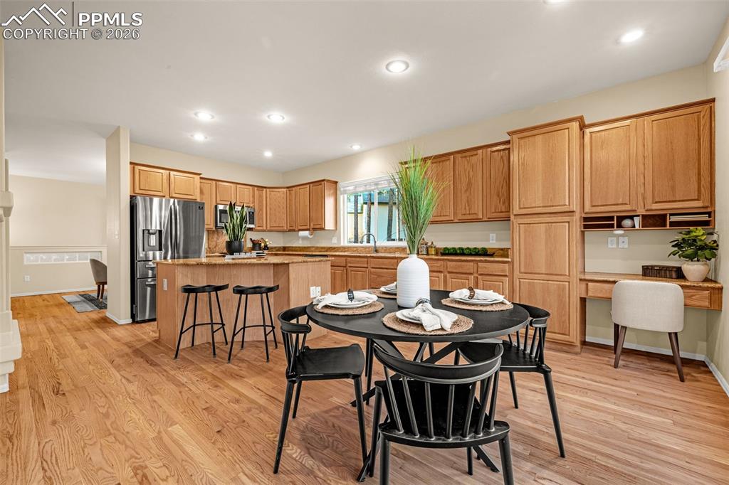 Image 12 of 40: Open concept kitchen and dining area with hardwood floors, recessed lightin