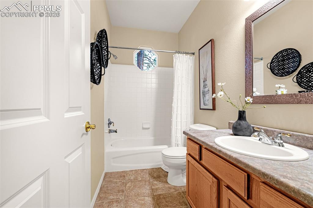 Image 17 of 40: This bathroom features a single vanity with a white sink and chrome faucet,