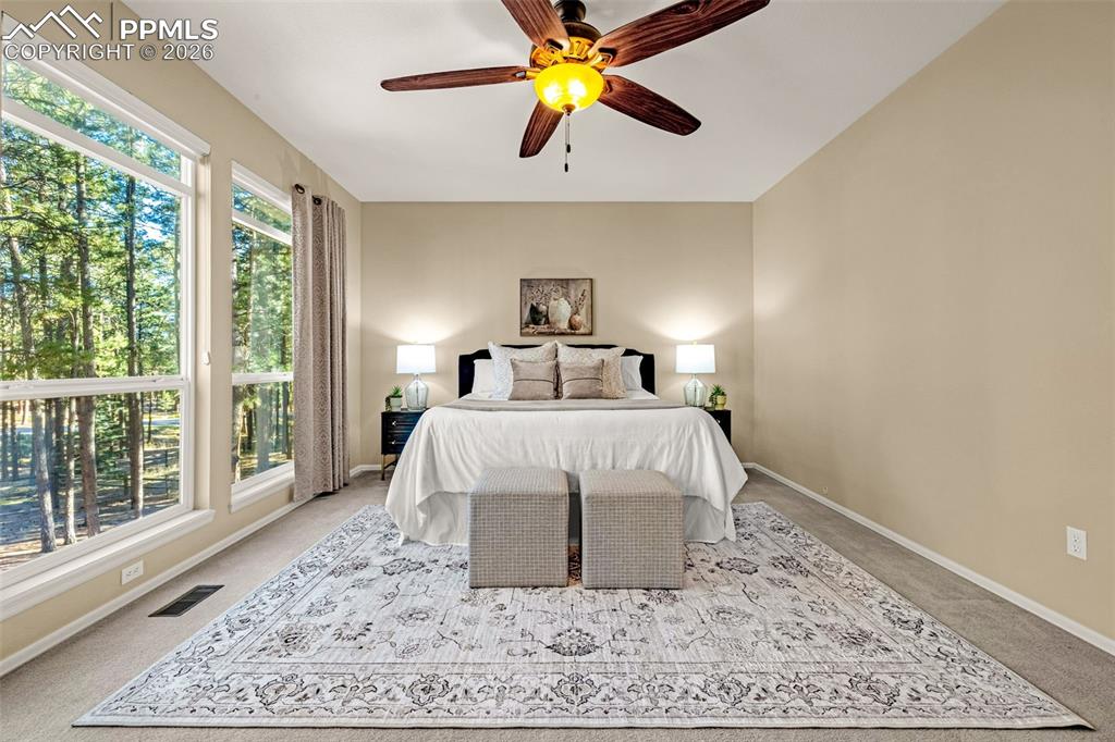 Image 19 of 40: This bedroom features expansive windows, offering natural light and views o