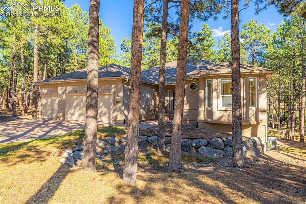 Image 2 of 40: The property features a stucco exterior, a 3-car garage, and a bay window, 