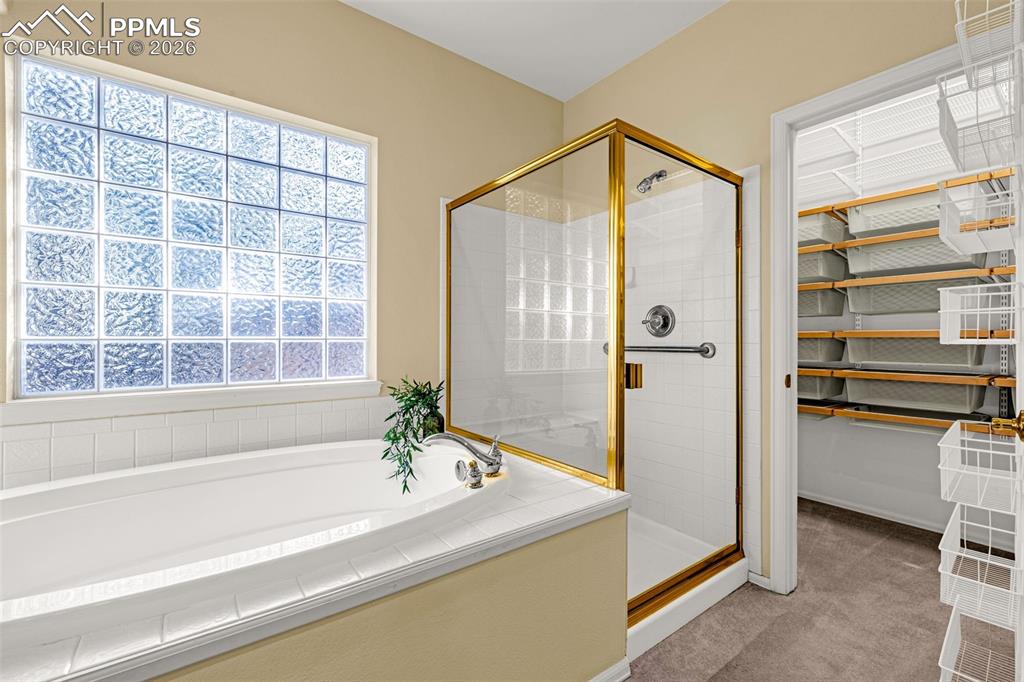 Image 25 of 40: The bathroom features a built-in bathtub, a glass block window, and a stand