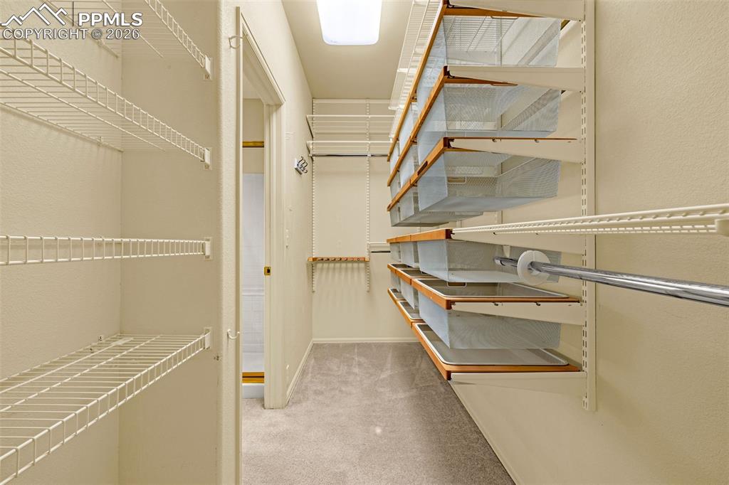 Image 26 of 40: Spacious closet featuring white wire shelving, pull-out mesh baskets with w