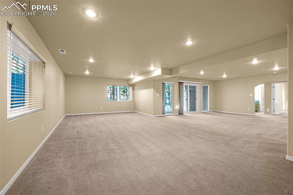 Image 27 of 40: Spacious room featuring neutral carpeting, recessed lighting, and wall-to-w