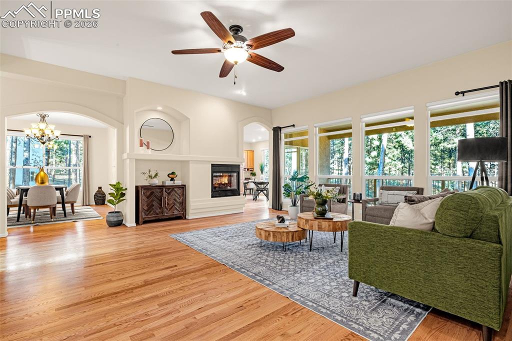 Image 3 of 40: The living area features hardwood floors, a ceiling fan with integrated lig