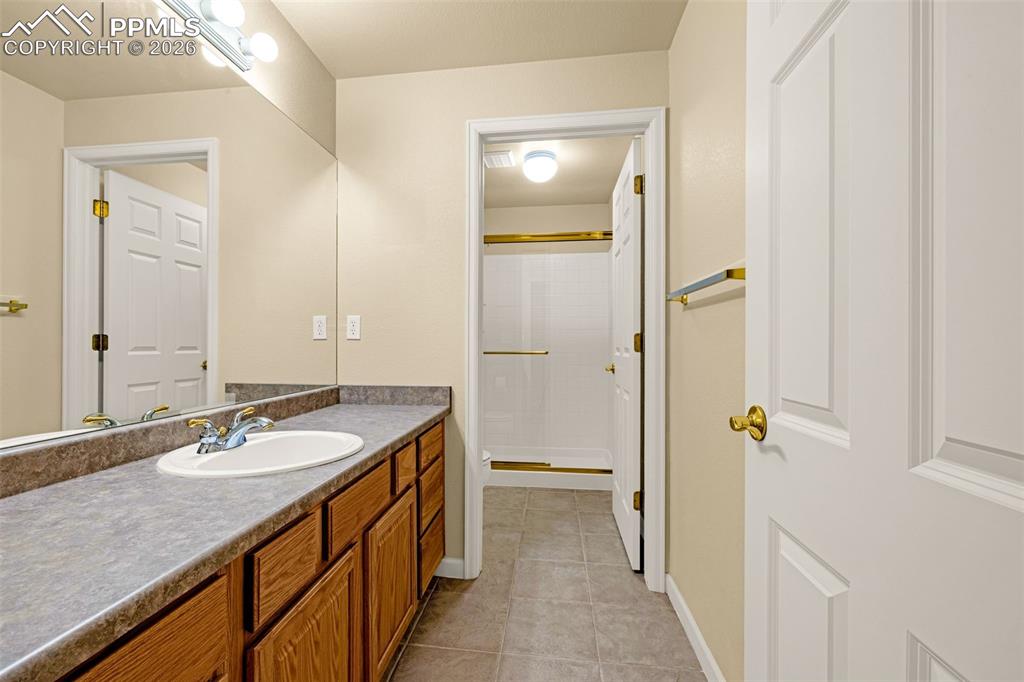 Image 31 of 40: The downstairs bathroom offers plenty of cabinet space and a large walk-in 