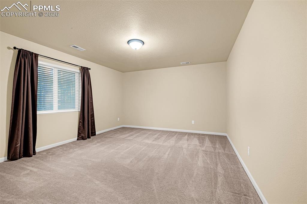 Image 32 of 40: This space features neutral-toned walls, a window with blinds, and recessed