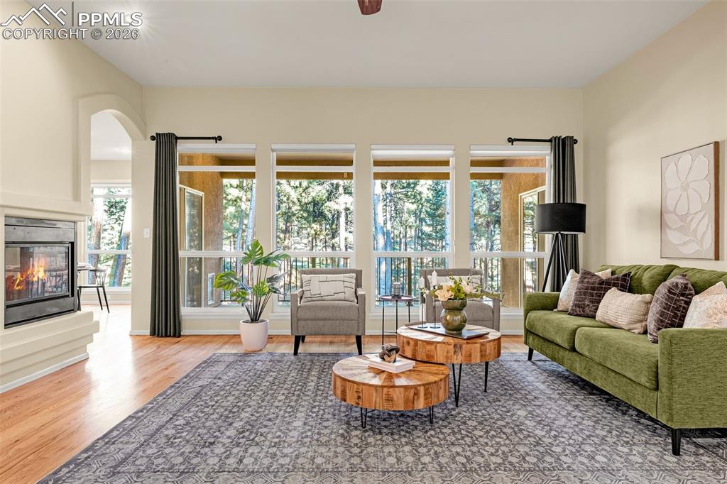 Image 5 of 40: Living area featuring hardwood floors, a fireplace with a bright and airy s