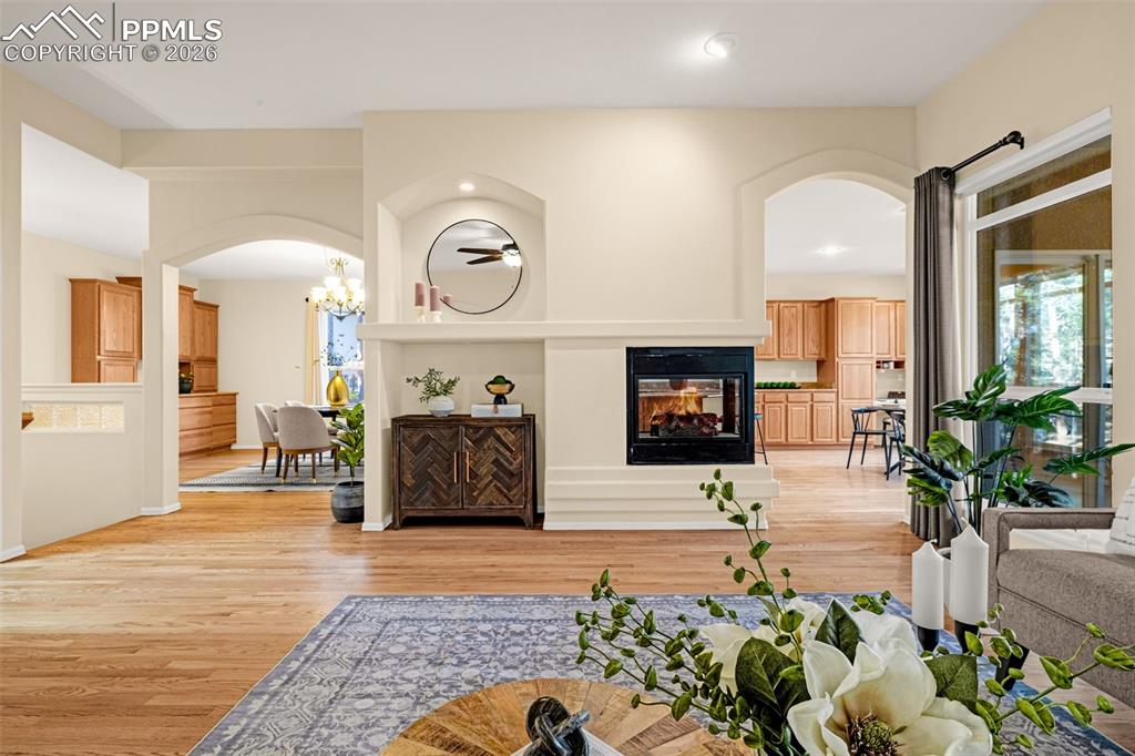Image 7 of 40: This property features hardwood floors, a fireplace, and arched doorways