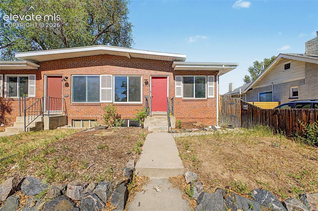 Image 1 of 40: Brick facade building featuring two distinct entryways with red doors
