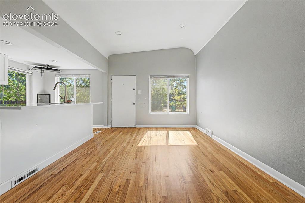 Image 12 of 40: Kitchen featuring white cabinetry, light countertops, and wood-finish floor