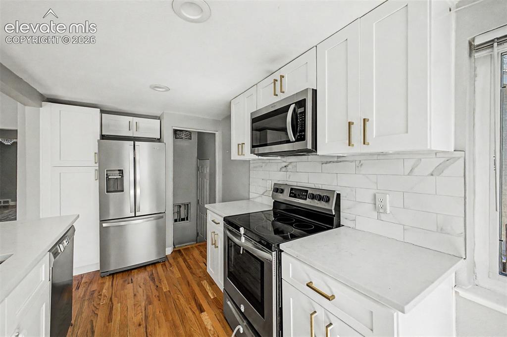 Image 14 of 40: Kitchen featuring white shaker cabinetry, stainless steel appliances, light