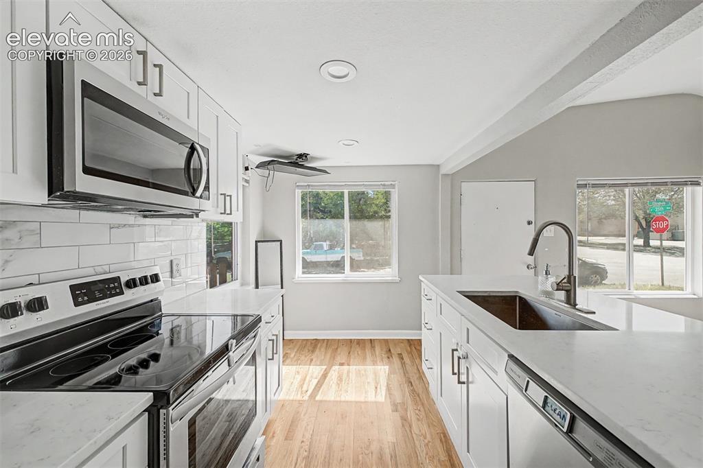 Image 17 of 40: Recessed window, wood-finish flooring, and a crystal chandelier