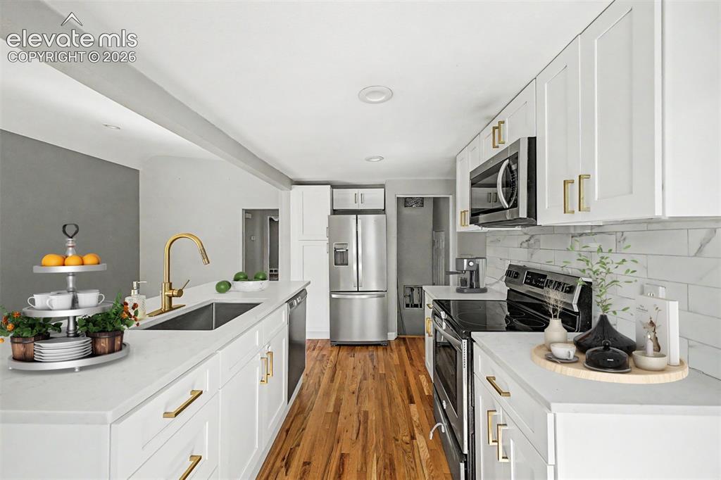 Image 7 of 40: Open-concept living space featuring wood-finish flooring, recessed lighting