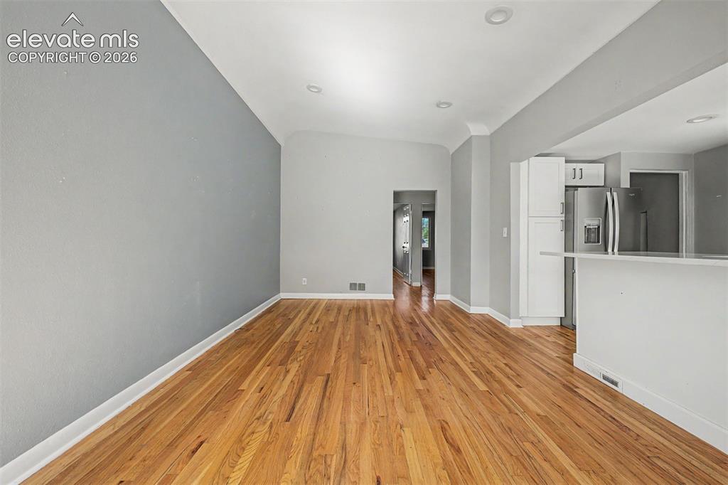 Image 8 of 40: Open-concept living space featuring wood-finish flooring, recessed lighting