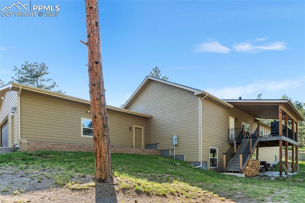 Image 2 of 46: Rear view of house with stairs and a deck
