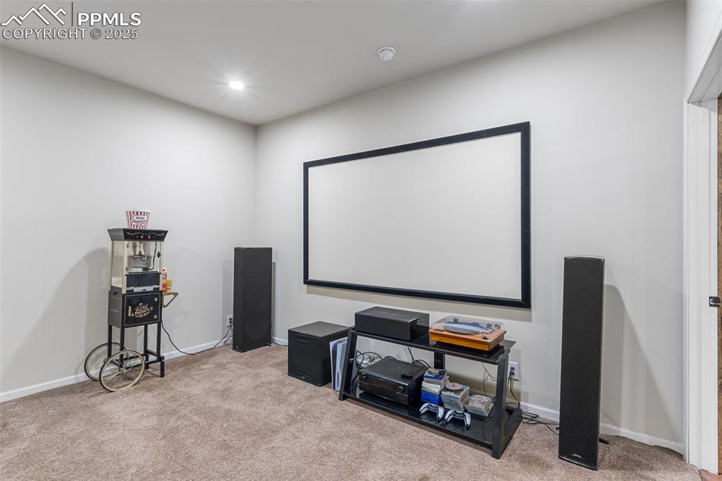 Image 21 of 46: Carpeted home theater room with baseboards and recessed lighting
