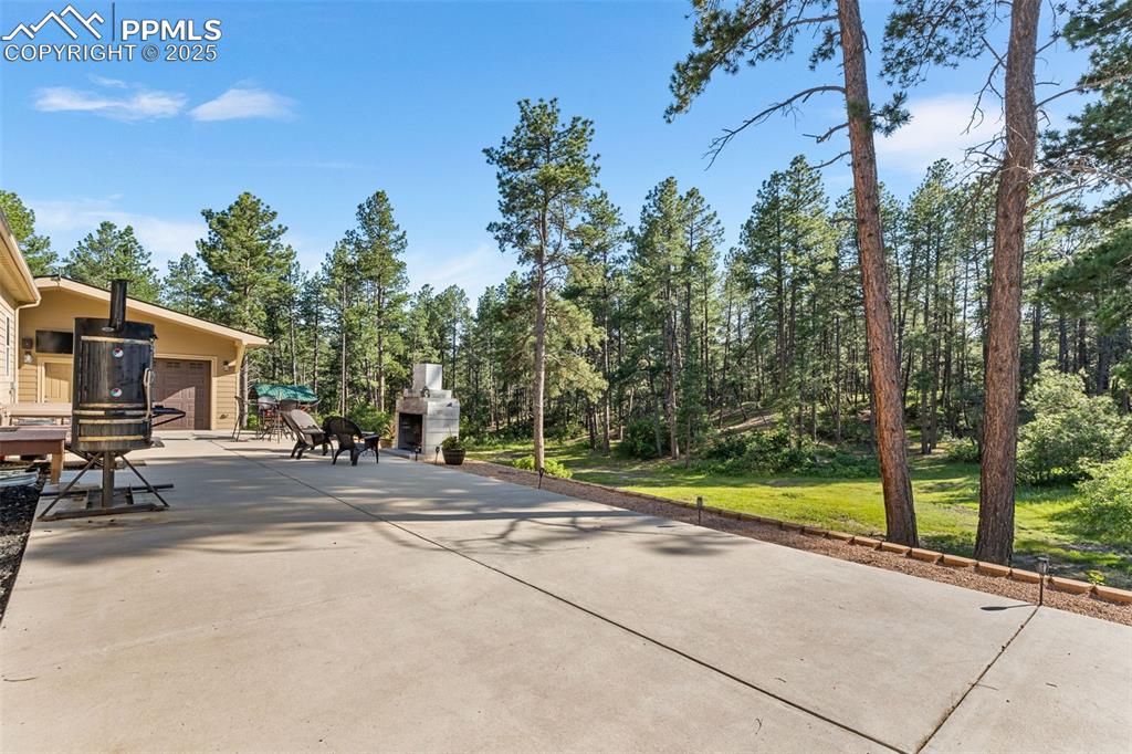 Image 33 of 46: View of patio with a garage and driveway