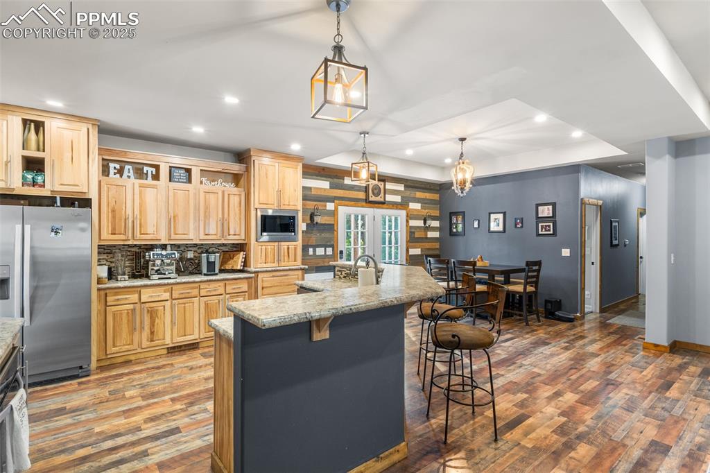 Image 4 of 46: Kitchen featuring open shelves, stainless steel appliances, light brown cab