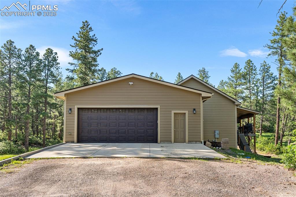 Image 43 of 46: View of front facade with concrete driveway, an attached garage, and stairw