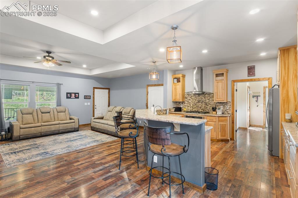 Image 5 of 46: Kitchen with light brown cabinets, open floor plan, dark wood-type flooring