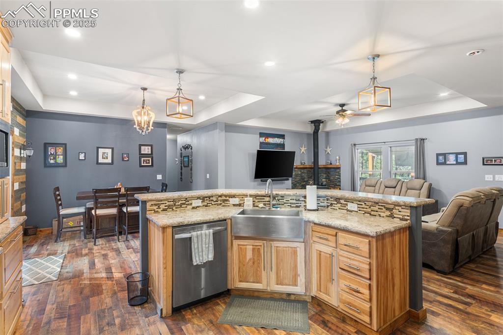 Image 6 of 46: Kitchen featuring a raised ceiling, open floor plan, dark wood finished flo