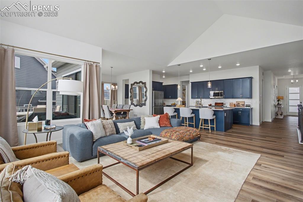 Image 10 of 39: Living area featuring wood finished floors, a high ceiling, and recessed li