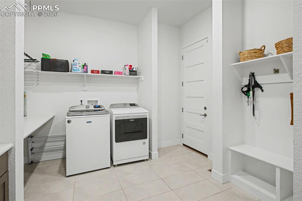 Image 20 of 39: Laundry room featuring washing machine and clothes dryer and light tile pat