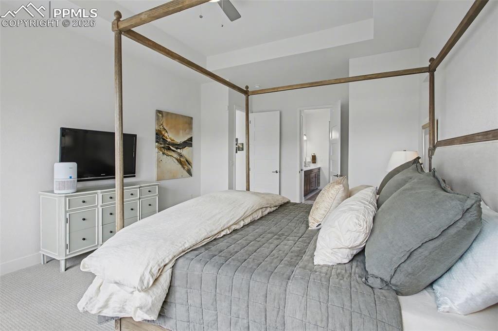 Image 23 of 39: Carpeted bedroom featuring ceiling fan and connected bathroom