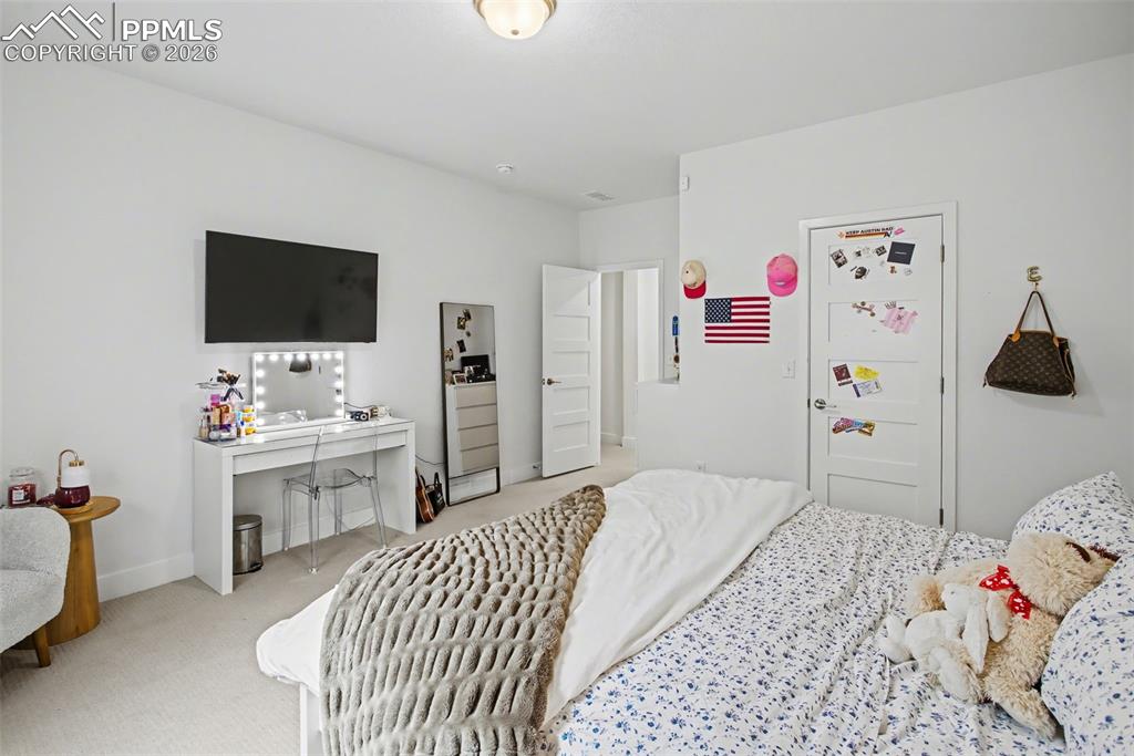 Image 28 of 39: Bedroom with light carpet and baseboards