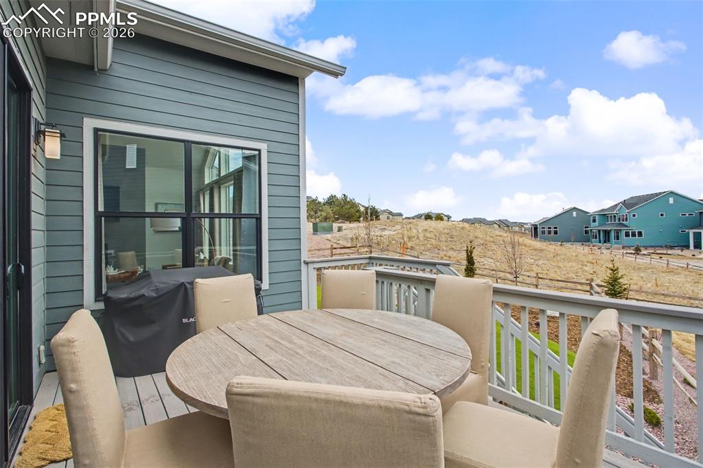Image 34 of 39: View of wooden balcony with outdoor dining area, a wooden deck, and area fo