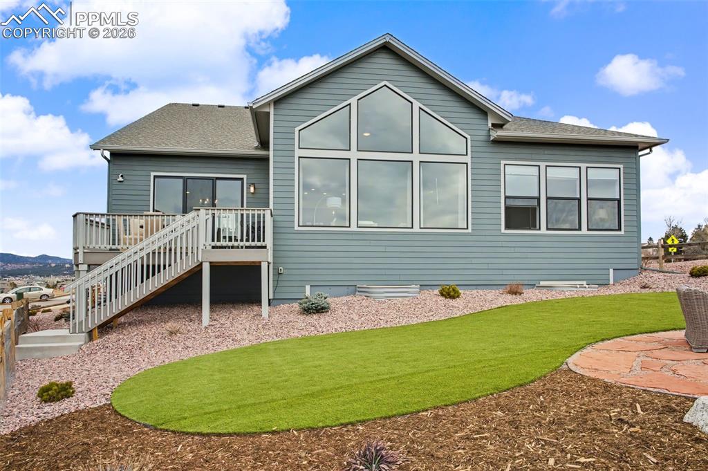 Image 35 of 39: Rear view of house with roof with shingles and a wooden deck