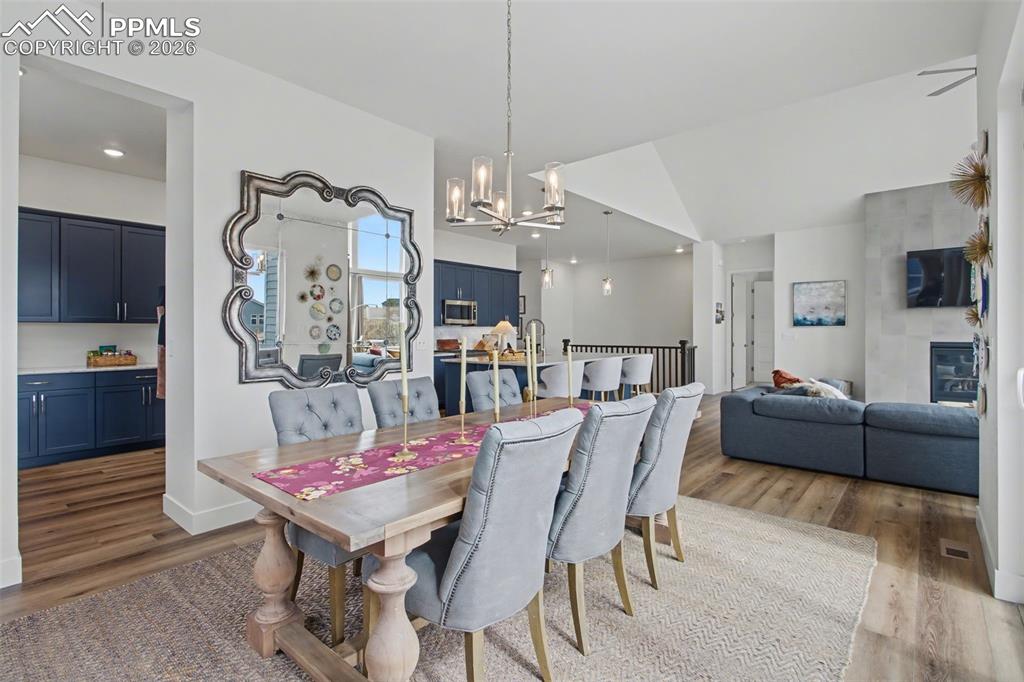 Image 8 of 39: Dining room with light wood-style floors, hanging lights, and vaulted ceili