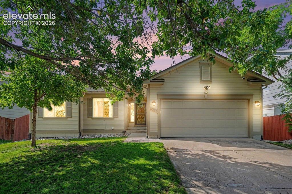 Caption: This inviting ranch-style home is tucked among mature trees and lush green grass