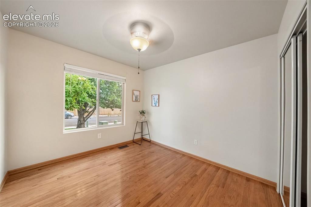 Image 14 of 28: The third main-level bedroom offers the warmth and character of real wood f