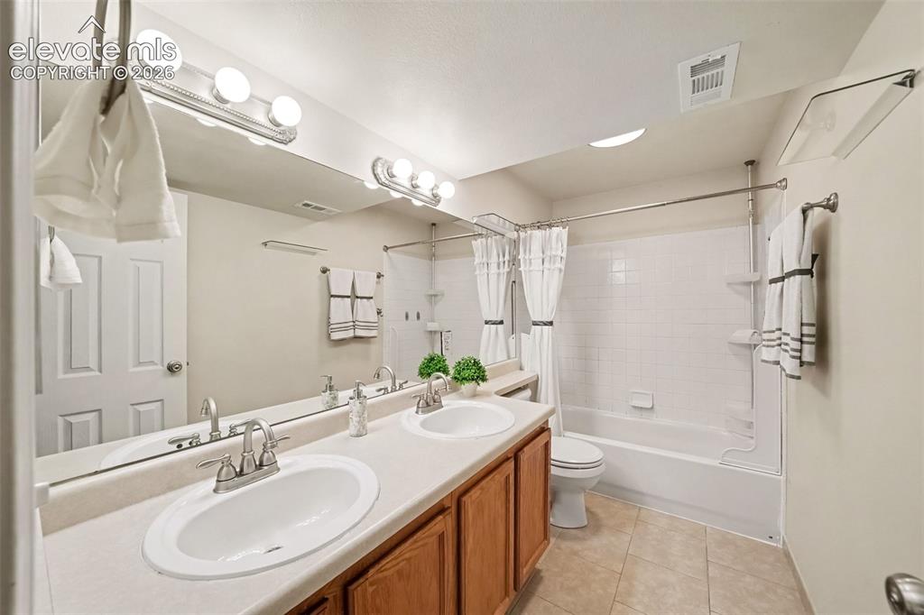 Image 24 of 28: The full basement bathroom features dual sinks and a spacious layout, provi