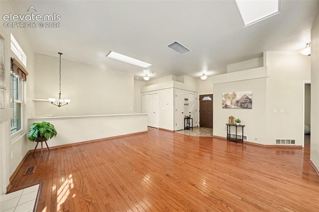 Image 6 of 28: The inviting living room features beautiful real wood flooring.