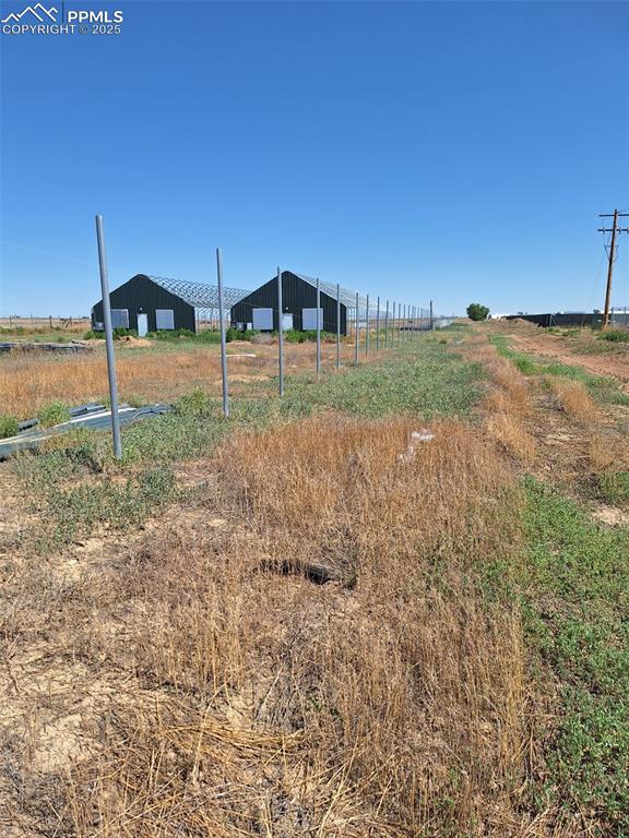 Image 17 of 24: View of yard featuring a pole building, a view of countryside, and an outdo