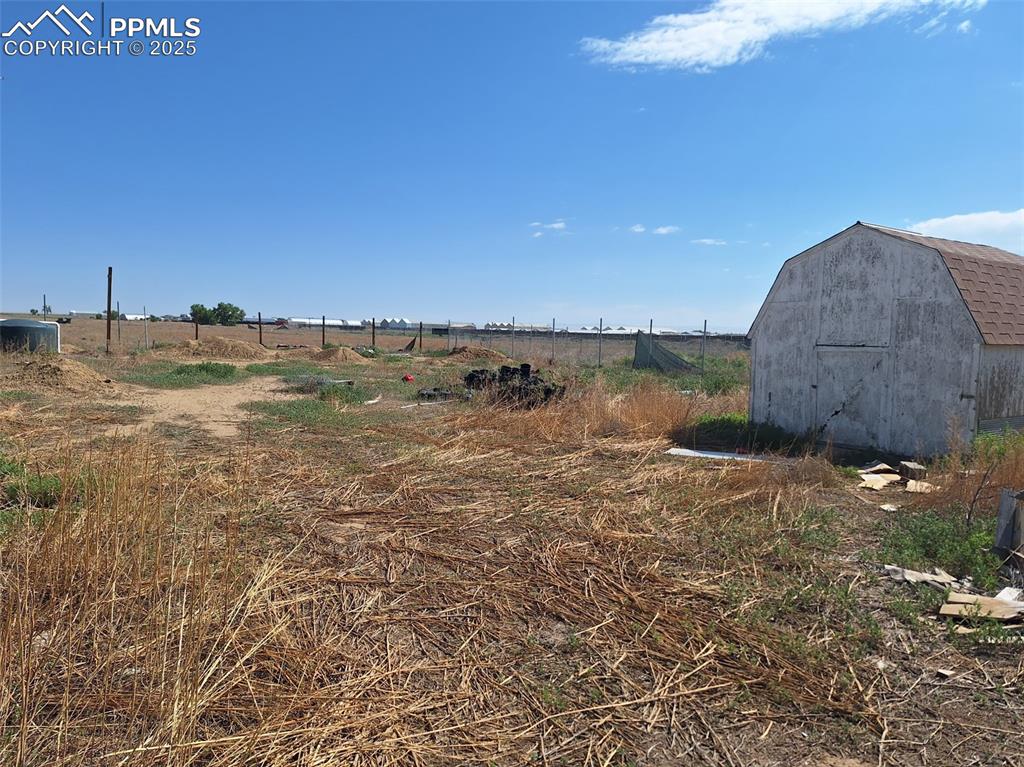 Image 22 of 24: View of yard featuring a view of rural / pastoral area and a storage shed