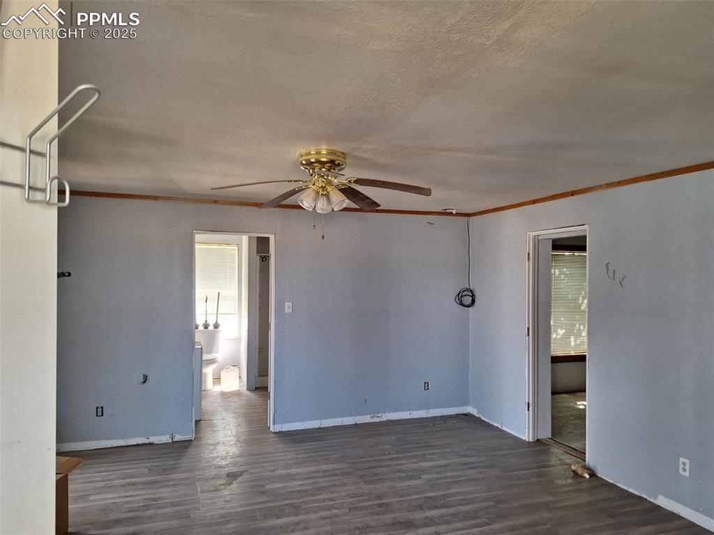 Image 4 of 24: Empty room featuring ornamental molding, dark wood-type flooring, a ceiling