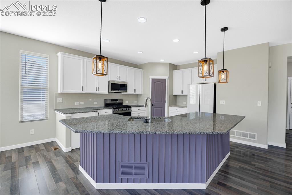 Image 11 of 50: Well-appointed kitchen featuring white cabinetry, stainless steel appliance