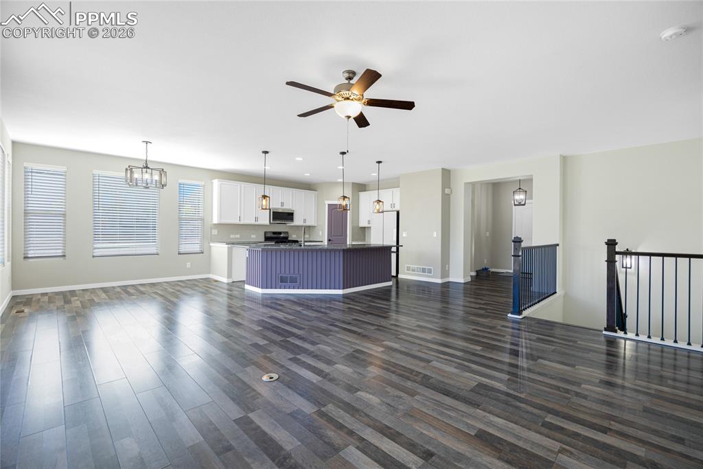 Image 14 of 50: This open concept living area features dark wood-style flooring, a ceiling 