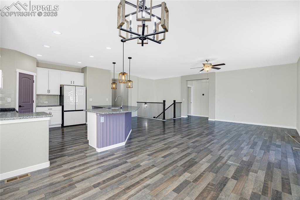 Image 15 of 50: Spacious open-concept living area featuring wood-look flooring, white cabin