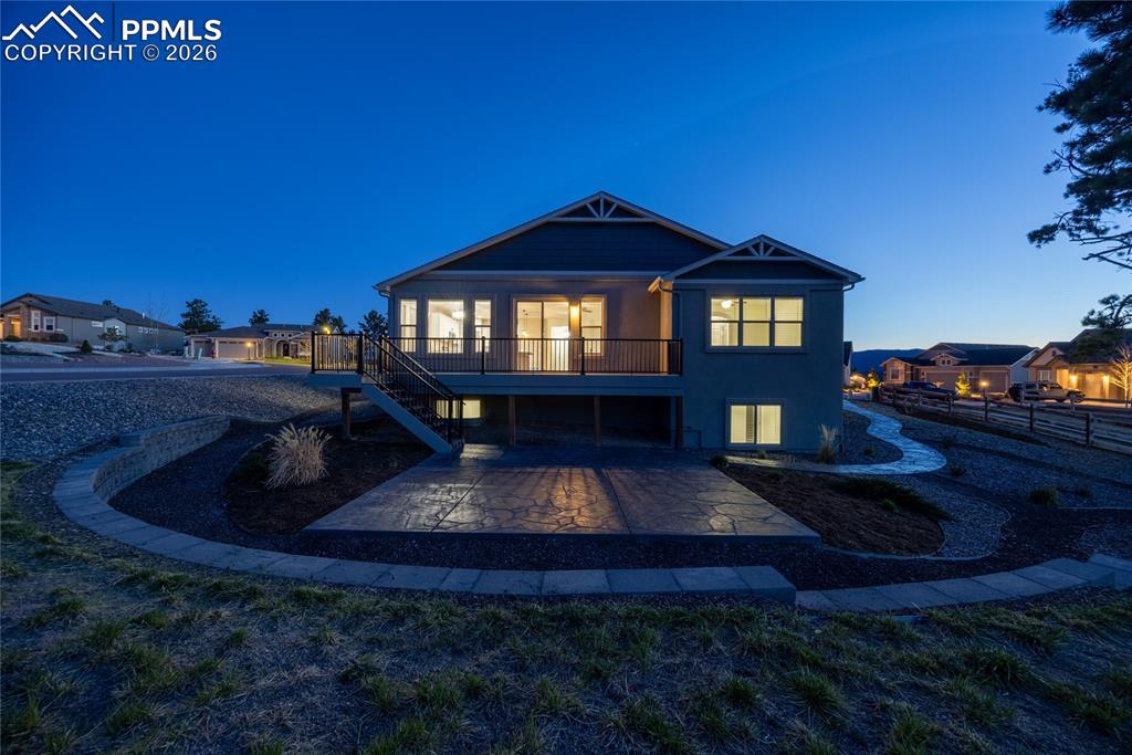 Image 3 of 50: The property features a private deck with stairs leading to a stamped concr