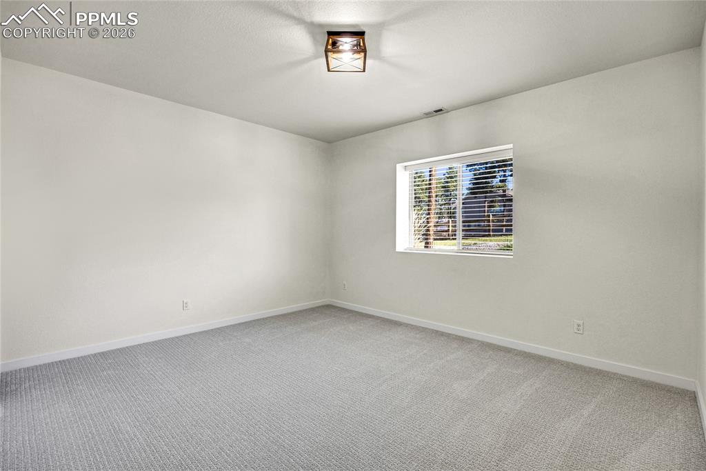 Image 45 of 50: The property features light gray carpeting, neutral white walls, and a wind