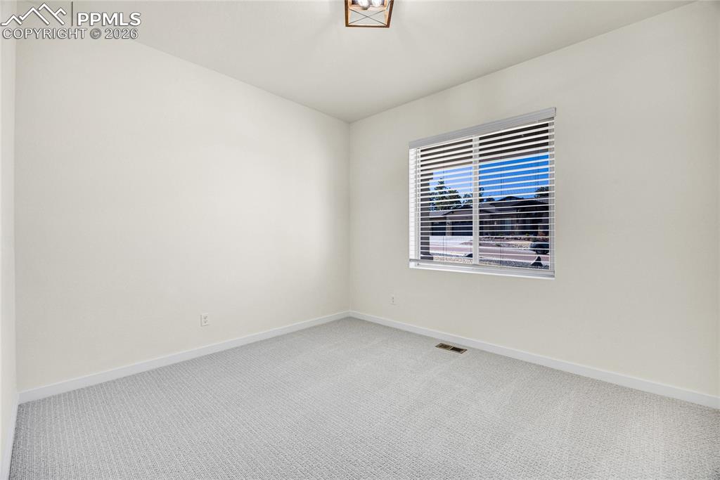 Image 49 of 50: This room features neutral-toned walls, light-colored carpet, and a window 