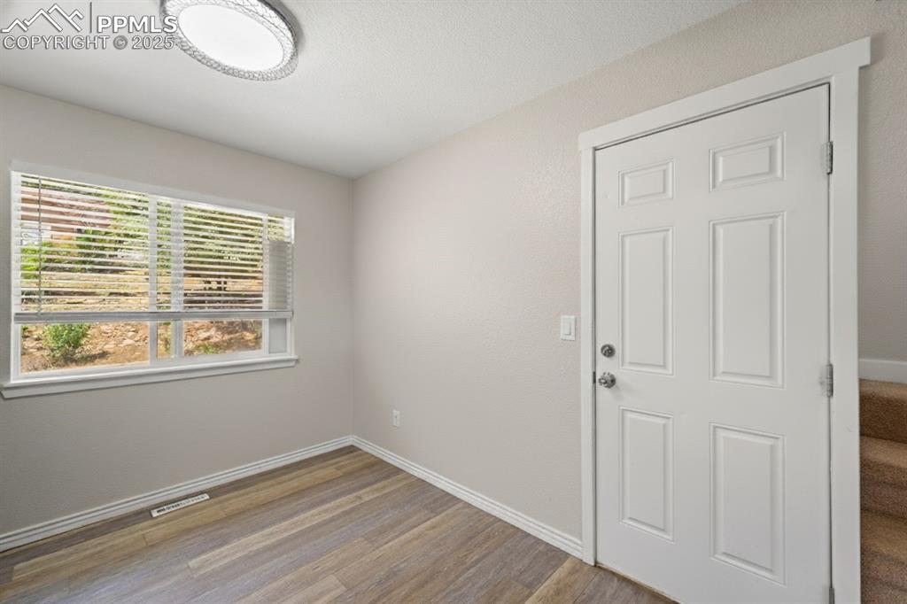 Image 10 of 48: Foyer entrance featuring wood finished floors and baseboards