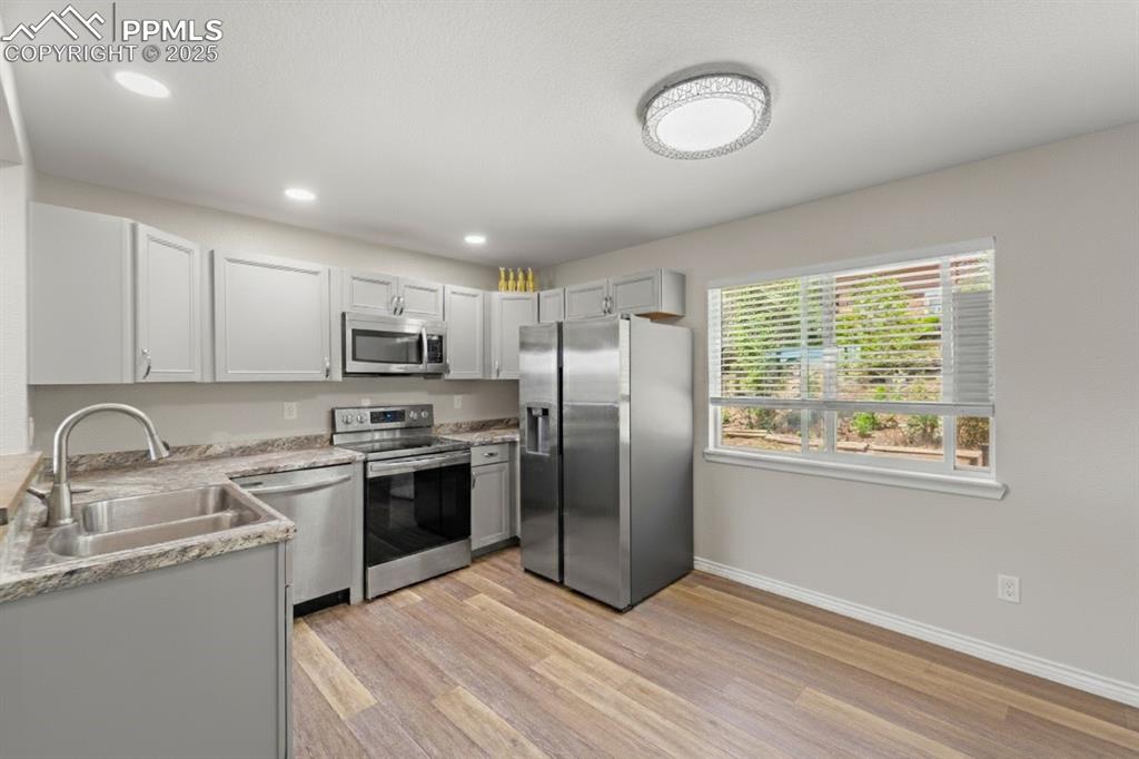 Image 11 of 48: Kitchen featuring appliances with stainless steel finishes, light wood-type